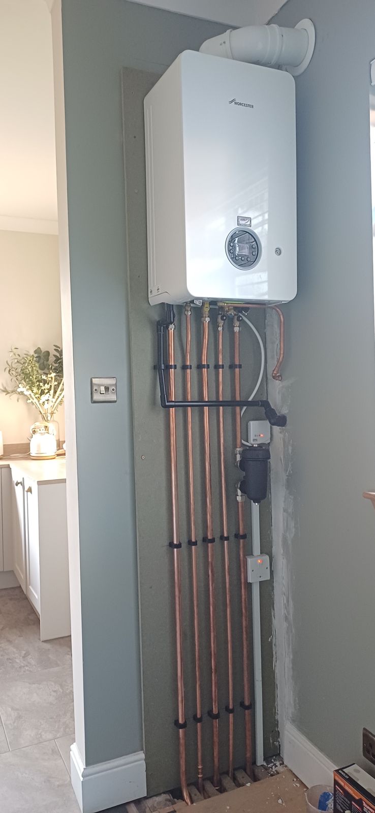 A new wall-hung combination boiler with neat copper pipework running down the wall